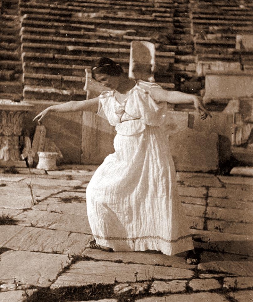 Isadora Duncan, pieds nus et en tunique grecque, dansant les bras ouverts sur les dalles d'un théâtre antique, le corps libre, rendu à lui-même.