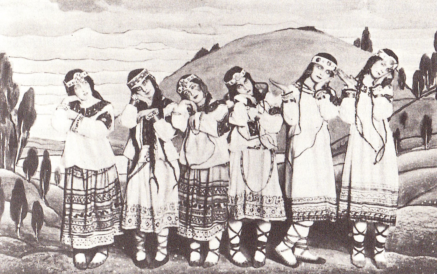 Groupe de danseuses de la création du Sacre du printemps en 1913, en costumes de Roerich, posées côte à côte, une main ramenée contre la joue, la tête penchée de côté.
